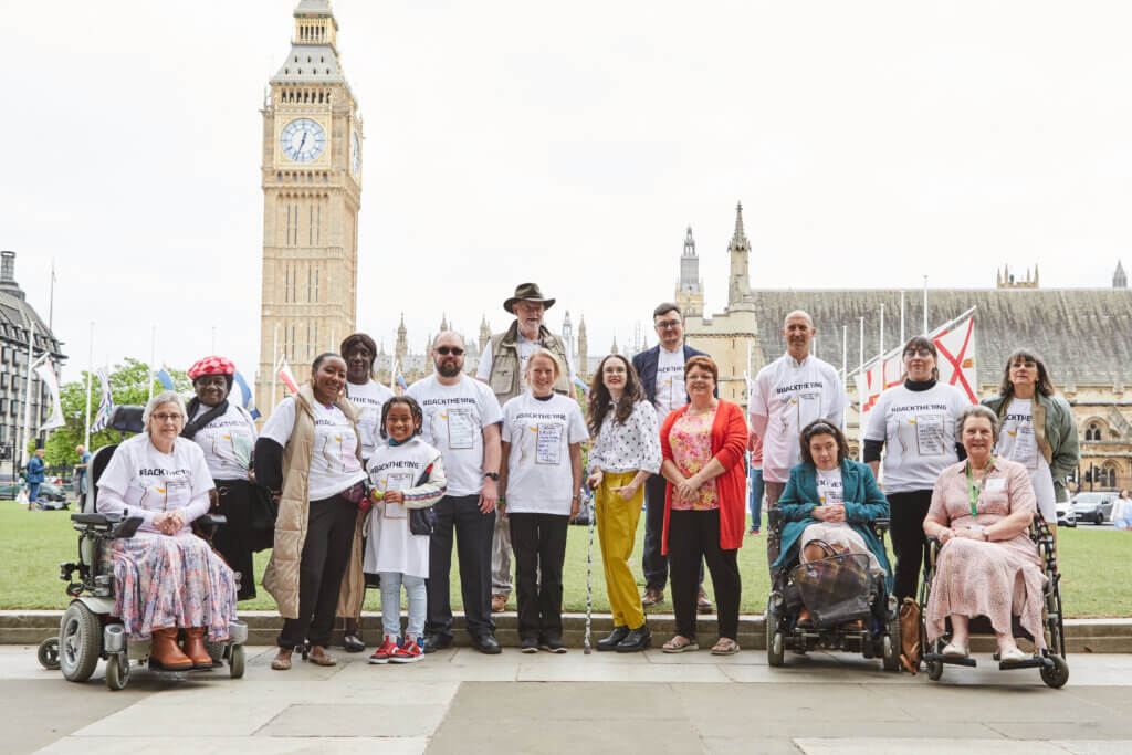 Members of the back the one in six hand-in delegation stand together. Big Ben is in the background.