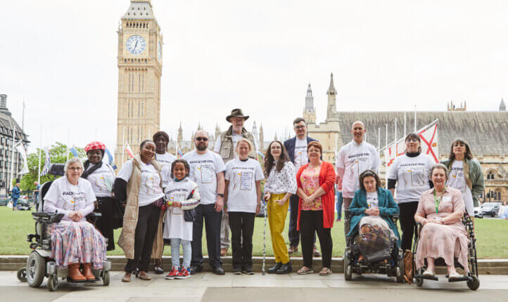 Members of the back the one in six hand-in delegation stand together. Big Ben is in the background.